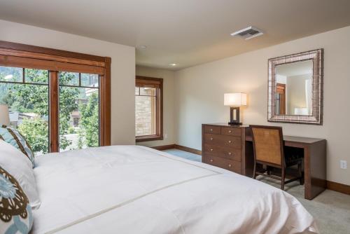 une chambre avec un lit, un bureau et un miroir dans l'établissement Chilali 25, à Ketchum