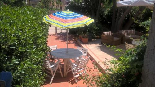 聖維托羅卡波的住宿－Casa Giummarra al primo piano，庭院内桌椅和遮阳伞