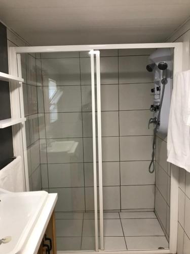 a shower with a glass door in a bathroom at A Casa do Avô Coelho in Santo Antão
