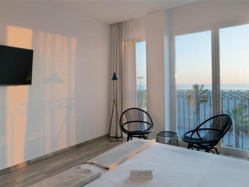 a bedroom with a bed and chairs and a balcony at Hotel Boutique Balandret in Valencia