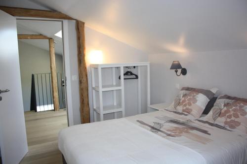 a bedroom with a large white bed and a mirror at Au Chat'rme des Blanches Pierres in Francorchamps