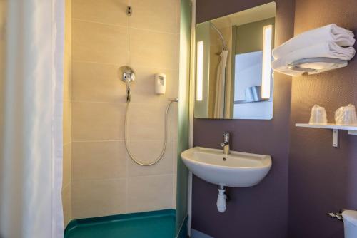 a bathroom with a sink and a shower at B&B HOTEL Lorient Caudan in Caudan