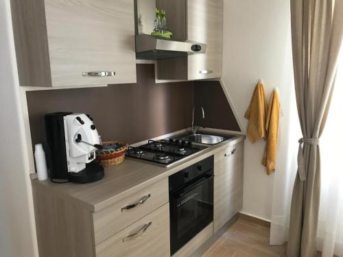 a small kitchen with a stove and a sink at Holiday In Home | Le Ciminiere in Catania