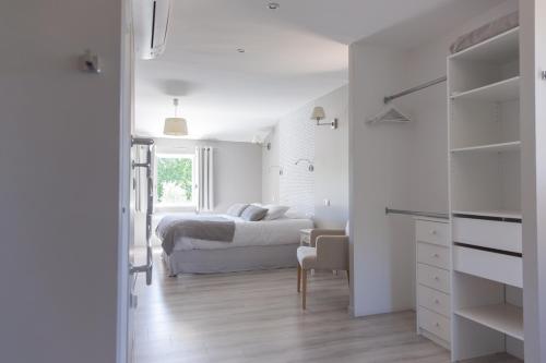 een witte slaapkamer met een bed en een bureau bij Le Mas des Alexandrins in Uzès