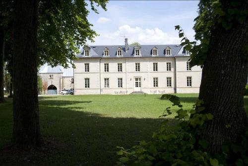 un gran edificio blanco con un árbol delante en Château De Lazenay - Résidence Hôtelière en Bourges