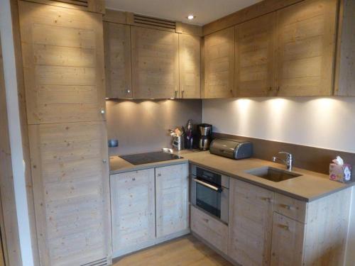 a kitchen with wooden cabinets and a sink at Nogentil in Saint-Bon-Tarentaise