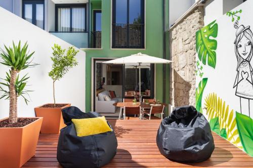 d'une terrasse avec des fauteuils à poufs noirs et des plantes. dans l'établissement Janika's Patio, à Porto