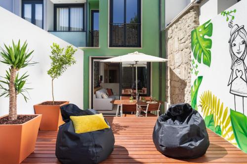 a patio with black bean bag chairs and plants at Janika's Patio in Porto