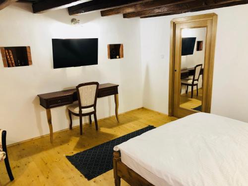 1 dormitorio con escritorio, 1 cama y espejo en V. Apartment, en Sighişoara