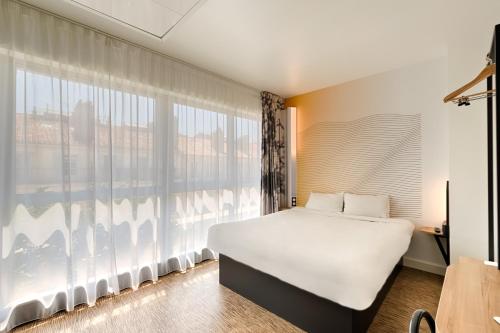 B&B HOTEL Marseille Centre La Joliette في مارسيليا: غرفة نوم بسرير ونافذة كبيرة