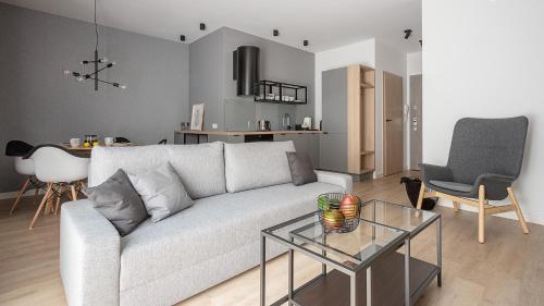 a living room with a white couch and a glass table at VIU Old Town Terrace in Gdańsk