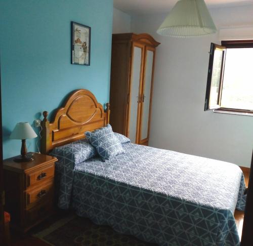 1 dormitorio con 1 cama, vestidor y ventana en O Cruceiro, en Lires