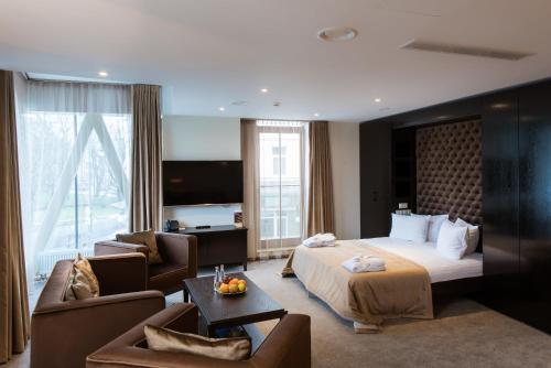 a hotel room with a bed and a living room at Amberton Cathedral Square Hotel Vilnius in Vilnius