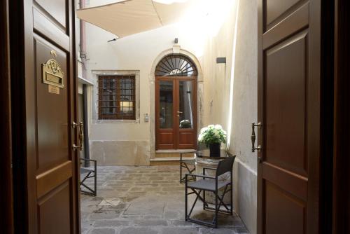 um corredor com uma porta, uma mesa e cadeiras em Residence La Fenice em Veneza