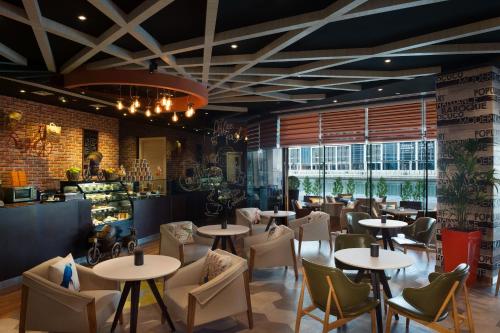 a restaurant with tables and chairs and a bar at Grand Mercure Business Bay in Dubai