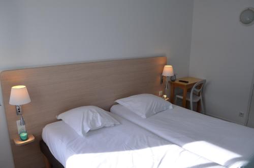 a bedroom with a large bed with white sheets and pillows at TERNELIA Le Vent Du Large in Saint-Gilles-Croix-de-Vie