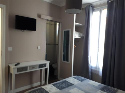 a bedroom with a bed and a television and a window at Hôtel Résidence Champerret in Levallois-Perret