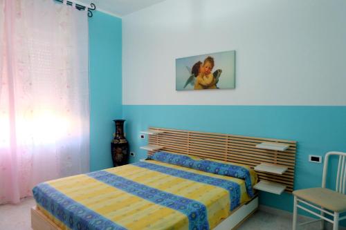 1 dormitorio azul con 1 cama y 1 silla en Angulum, en Citta' Sant'Angelo