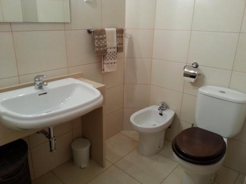 a bathroom with a toilet and a sink at Edificio Praia Mar Sol in Armação de Pêra