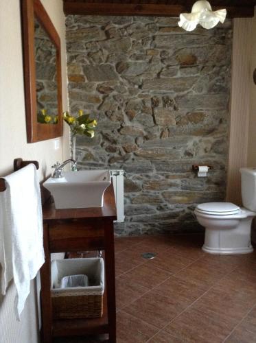 a stone bathroom with a sink and a toilet at Casa Portela in Portela de Portomourisco