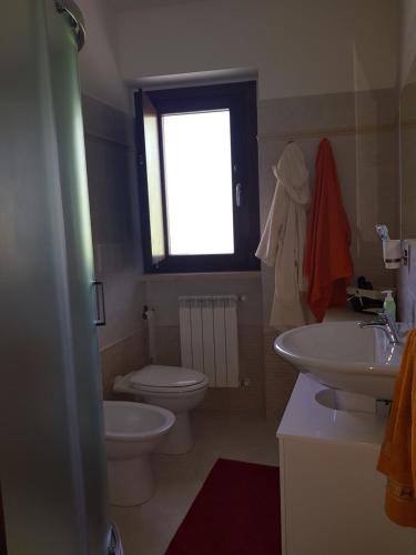 a bathroom with a toilet and a sink and a window at Il paradiso d'Oriente! in Tagliacozzo