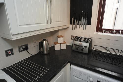 a kitchen with a counter top with a coffee maker at Silver Key Apartments in Inverness