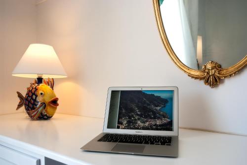 a laptop computer sitting on a table next to a lamp at Hotel Montemare in Positano