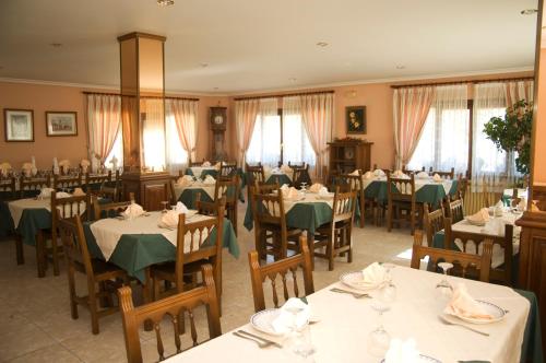 una sala da pranzo con tavoli e sedie con tovaglioli verdi di Posada Rural Peñasagra a Quintanilla