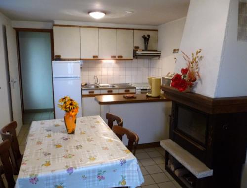 a kitchen with a table with a vase of flowers on it at Gîte Les Hirondelles in Plombières-les-Bains