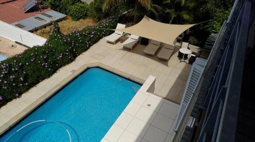 an overhead view of a swimming pool with chairs and trees at Upperbloem Guesthouse and Apartments in Cape Town