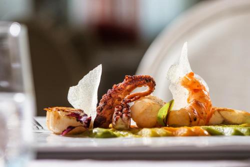 a plate with some food on a table at Baia del Mar Beach Boutique Hotel in Lido di Jesolo