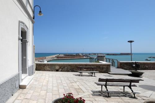 2 Bänke auf einer Terrasse mit Blick auf das Wasser in der Unterkunft Dimora Marinucci in Termoli