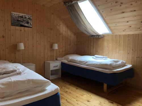 1 dormitorio con 2 camas y ventana. en Nordkappferie, en Gjesvær
