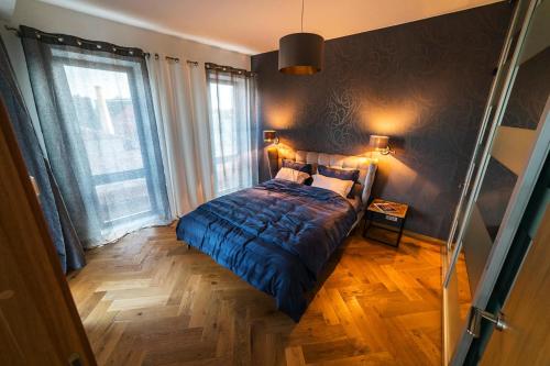 a bedroom with a bed with a blue comforter at Modern Luxury Apartment in City Centre in Tallinn