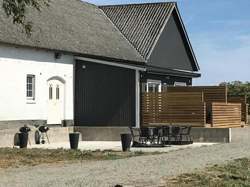 a building with a black roof and a group of chairs at Smultronstallet Gårdshotell in Valleberga