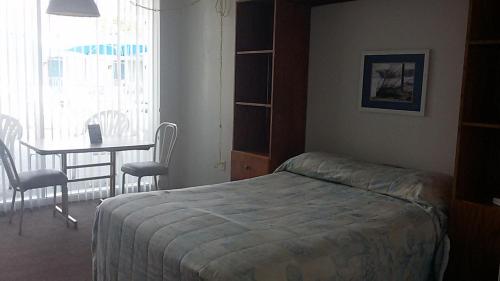 a bedroom with a bed and a table and chairs at Tide Winds Motel in Wildwood
