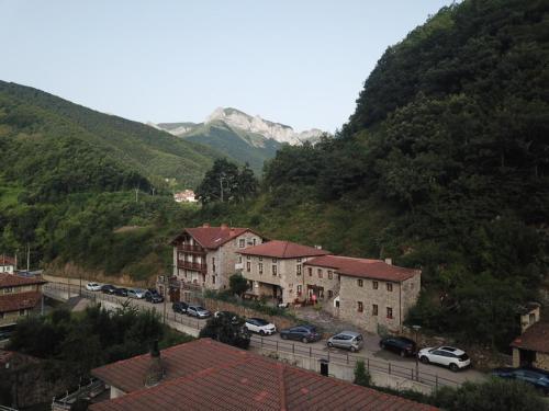 a town with cars parked in front of a mountain at Posada Sobrevilla in Espinama