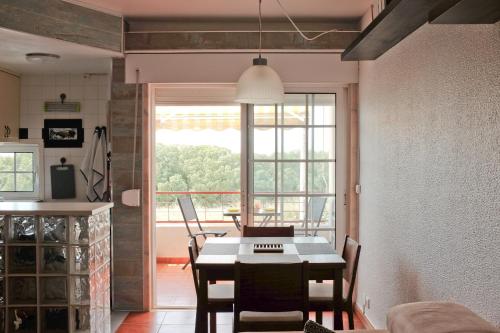 a kitchen and dining room with a table and a window at Like-home-T1 Apt-Sea View, near the beach in Carcavelos