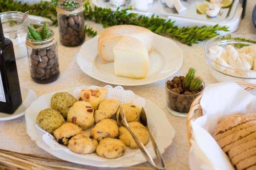 a table topped with plates of food and bread at Masseria Carignani in Tuglie