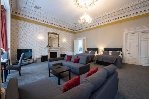 a living room with a couch and a living room with a tv at Grosvenor Suites in Edinburgh