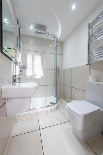 a bathroom with a toilet and a sink and a shower at Grosvenor Suites in Edinburgh