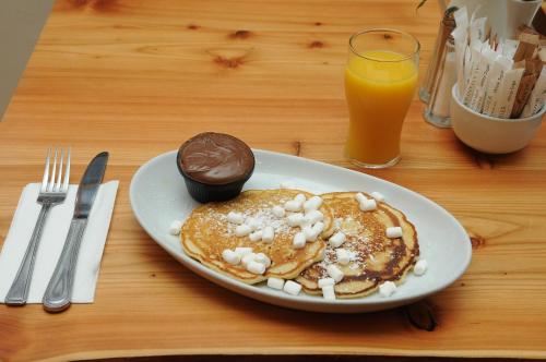 a plate of pancakes with nutella and a cup of orange juice at Lodge at The Old Barracks in Athenry