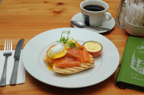 a plate of food with eggs on a table with a cup of coffee at Lodge at The Old Barracks in Athenry