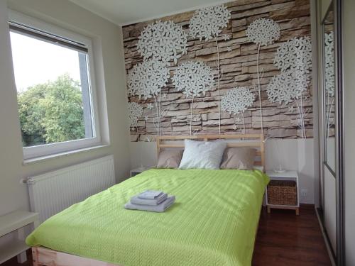 a bedroom with a green bed with a wooden wall at Sarni Stok in Bielsko-Biała
