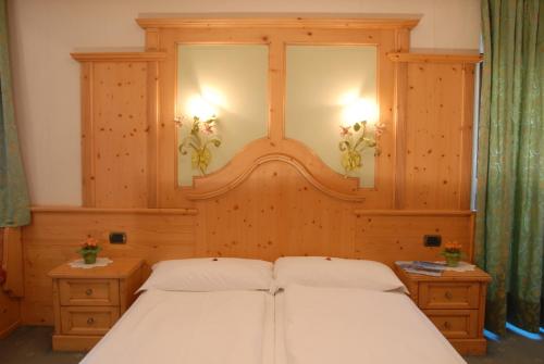 a bedroom with two white beds and two night stands at Hotel Loewenwirt in Sesto