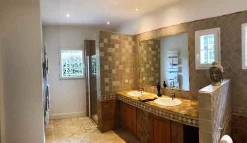 a bathroom with two sinks and a large mirror at Villa luxueuse avec piscine sur les hauts de Biarritz in Biarritz
