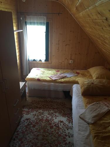a bedroom with two beds and a window at Vikendica na Zlatiboru in Zlatibor