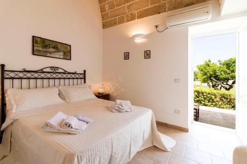 a bedroom with a bed with towels on it at Masseria Carignani in Tuglie