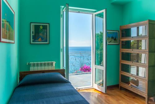 - une chambre avec un lit et une porte donnant sur un balcon dans l'établissement Villa Eliodora, à Arenzano