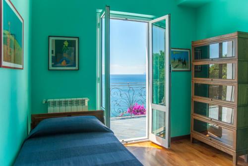 アレンツァーノにあるVilla Eliodoraのベッドルーム1室(ベッド1台付)、バルコニーへのドアが備わります。